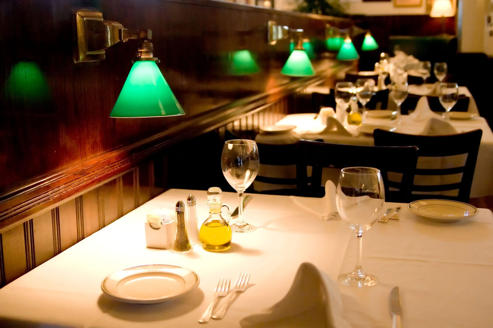 Elegant restaurant table with green lamps.