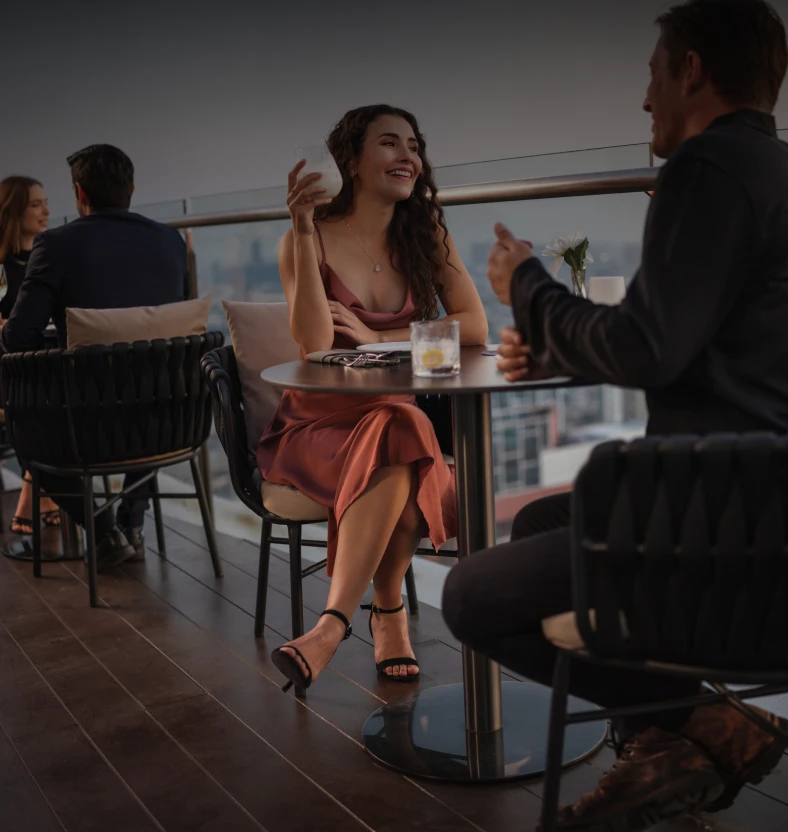 People enjoying drinks on rooftop patio.