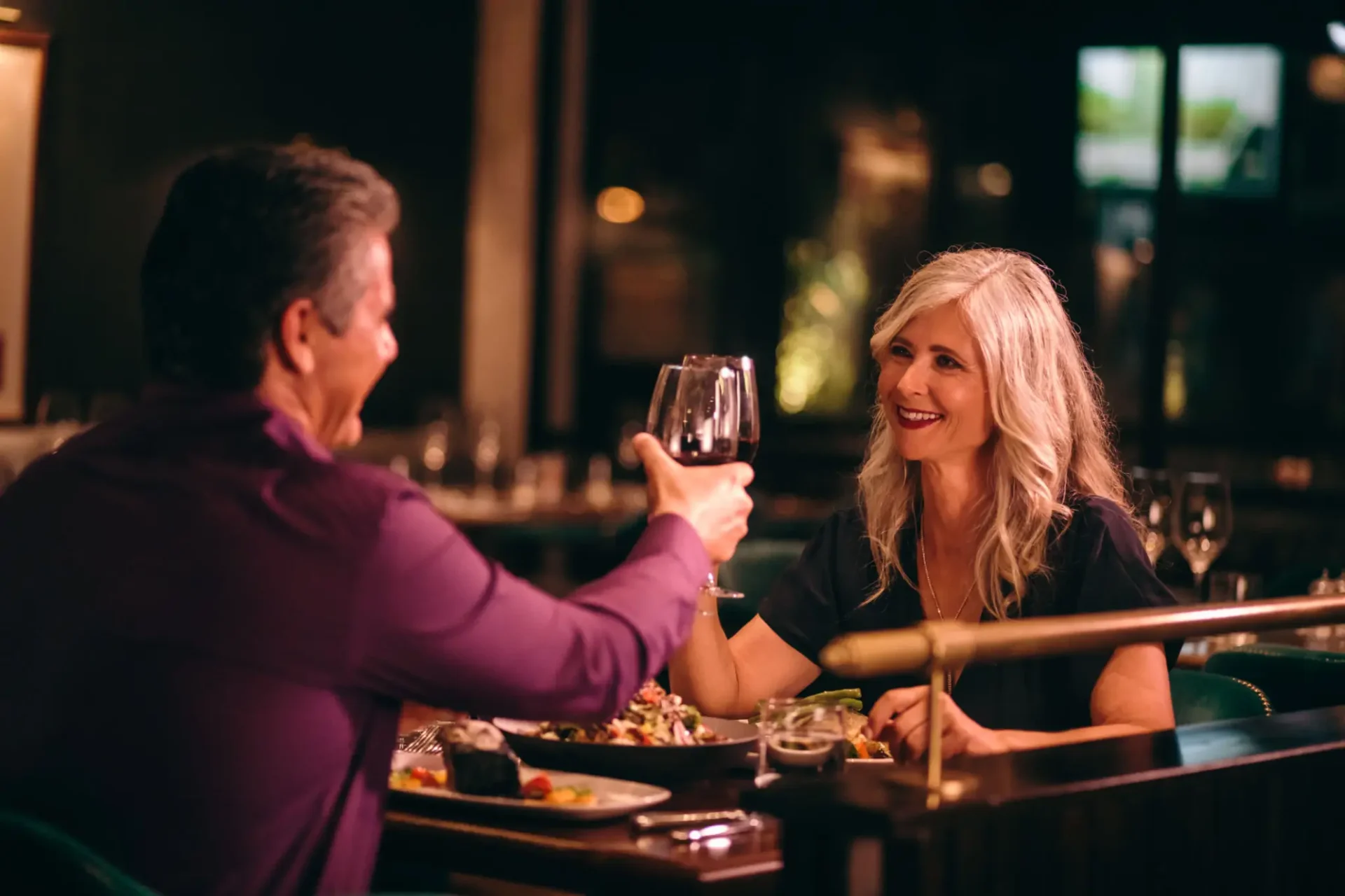 Couple enjoying a romantic dinner with wine at a cozy restaurant.