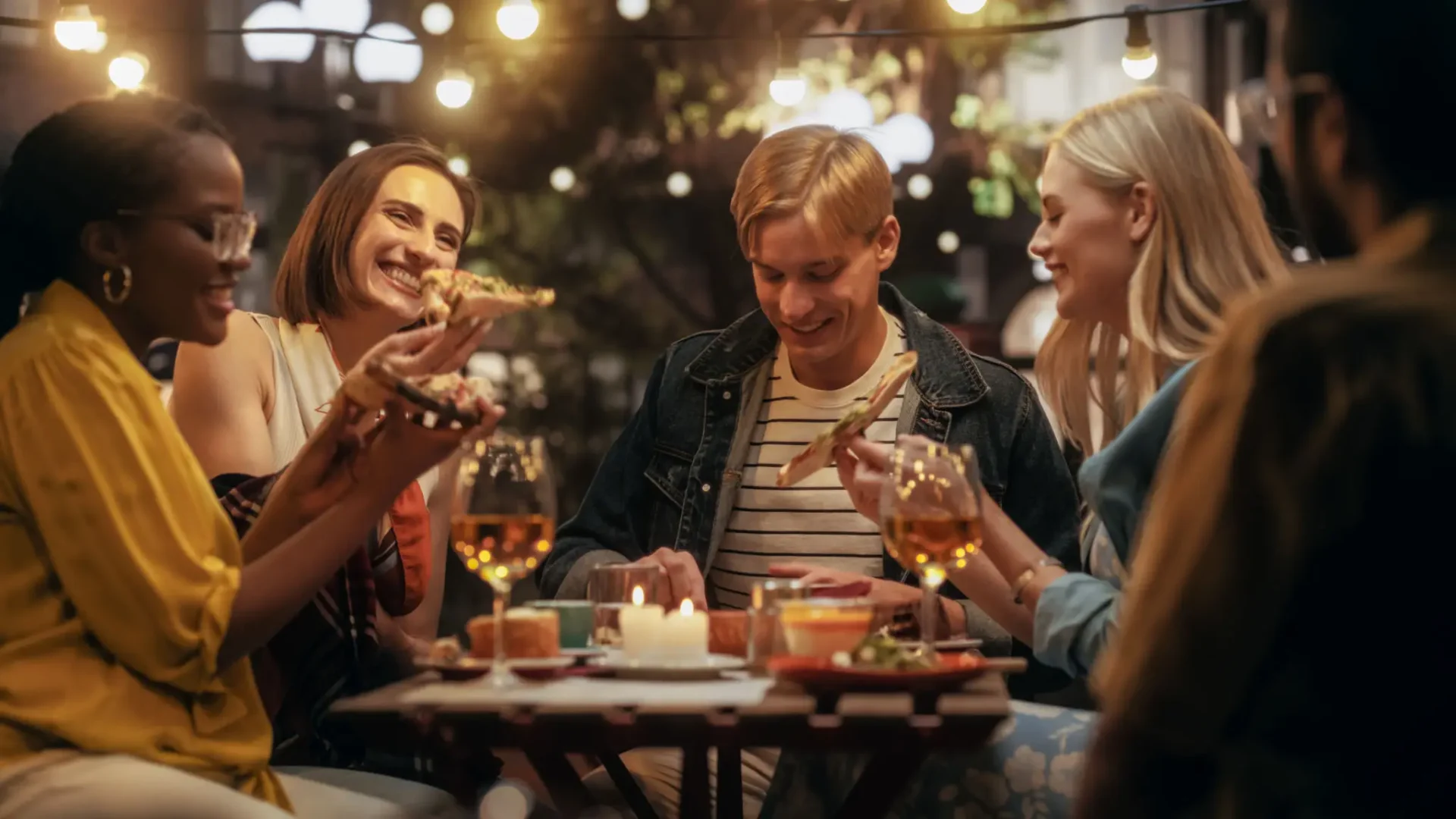 Friends enjoying drinks and dessert at a cozy outdoor cafe.